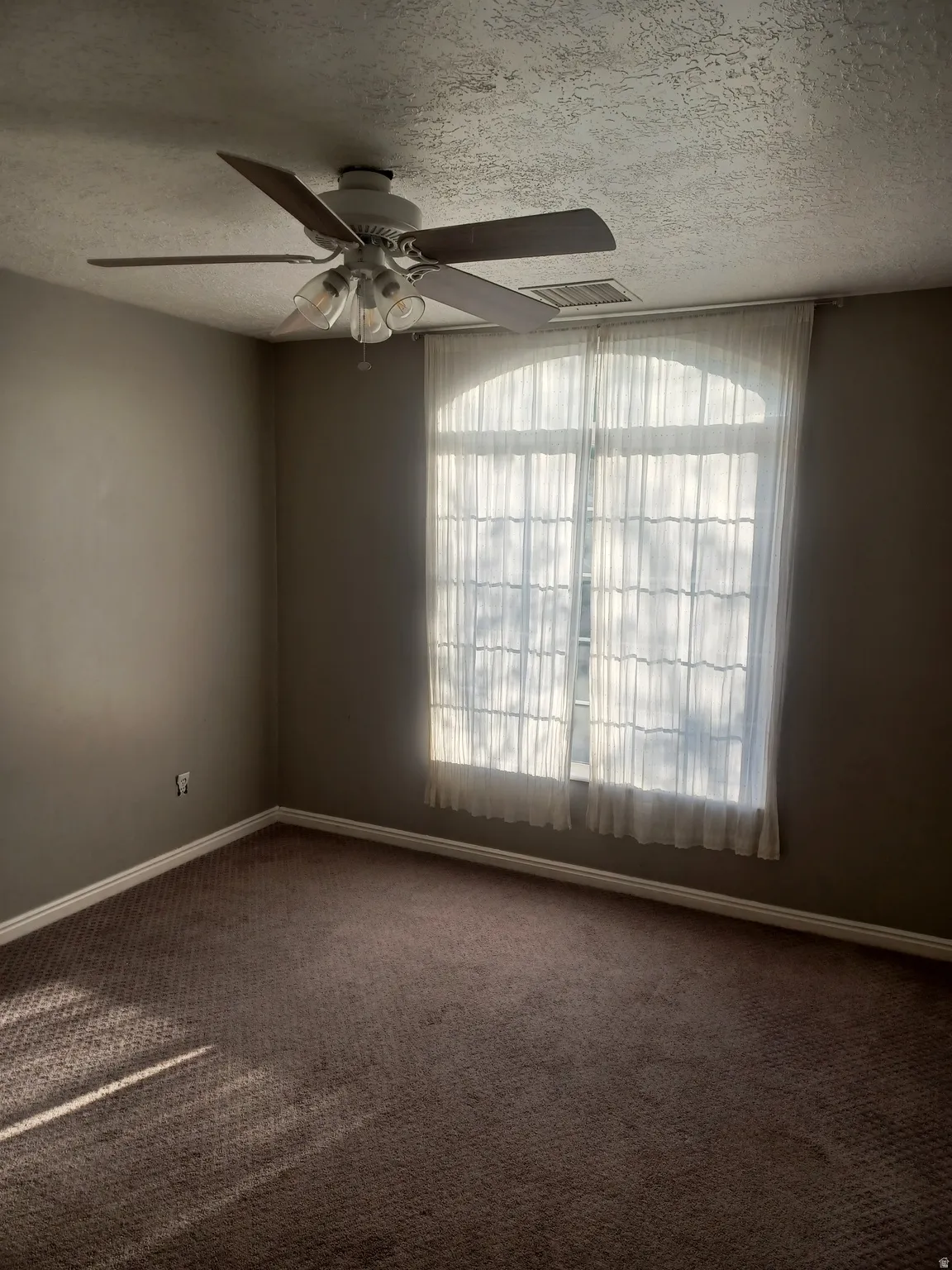 2nd bedroom upstairs. Carpeted featuring ceiling fan and a textured ceiling