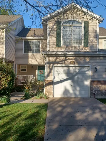 View of front of home with a garage, concrete driveway, brick siding, and a front yard
