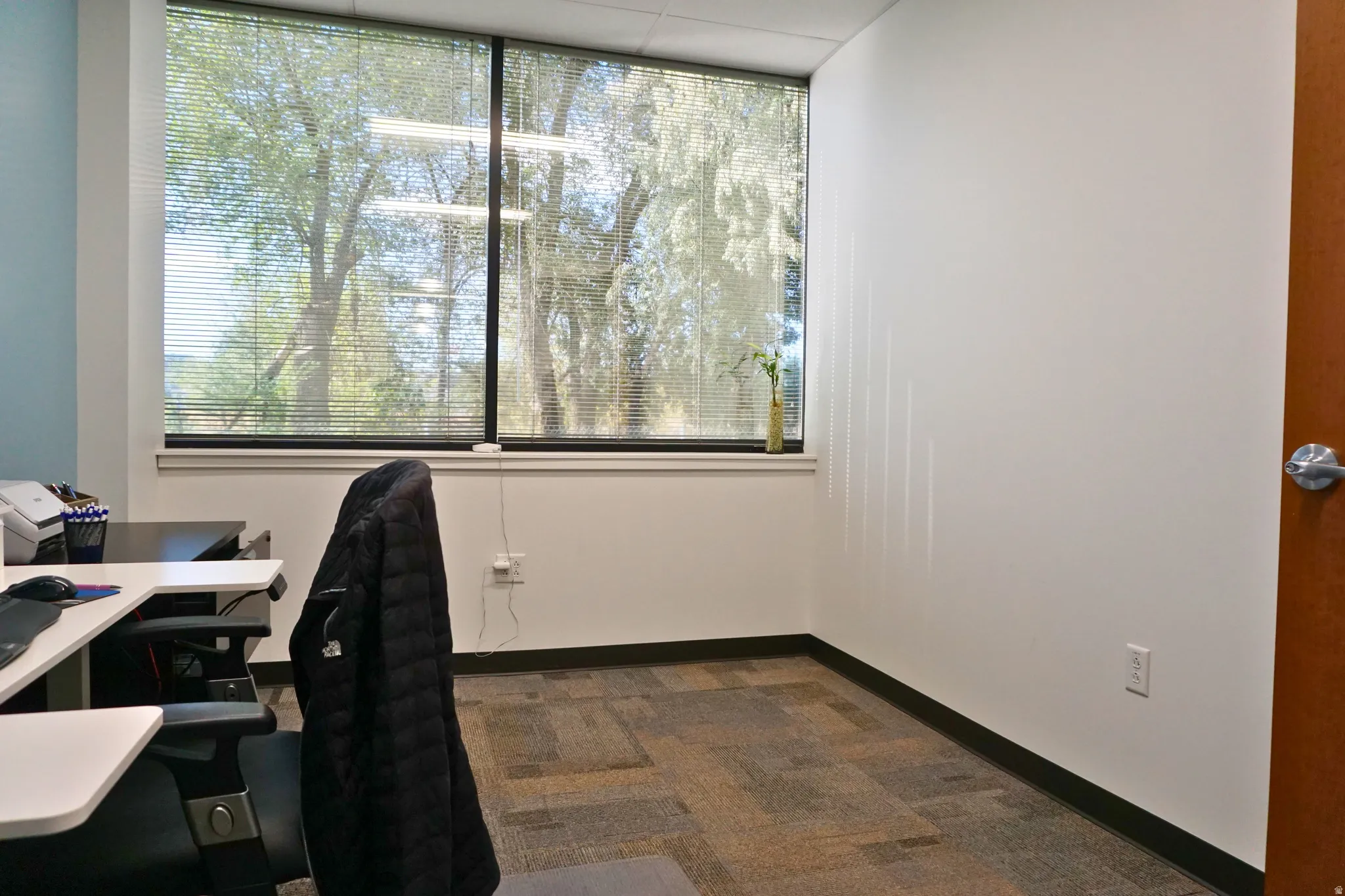 Office space featuring dark carpet and baseboards