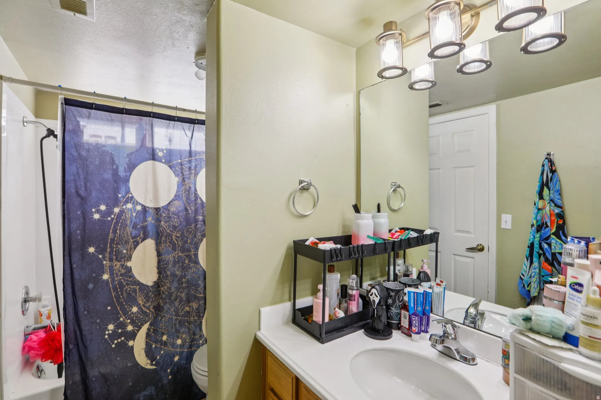 Bathroom featuring vanity and shower / bath combination with curtain