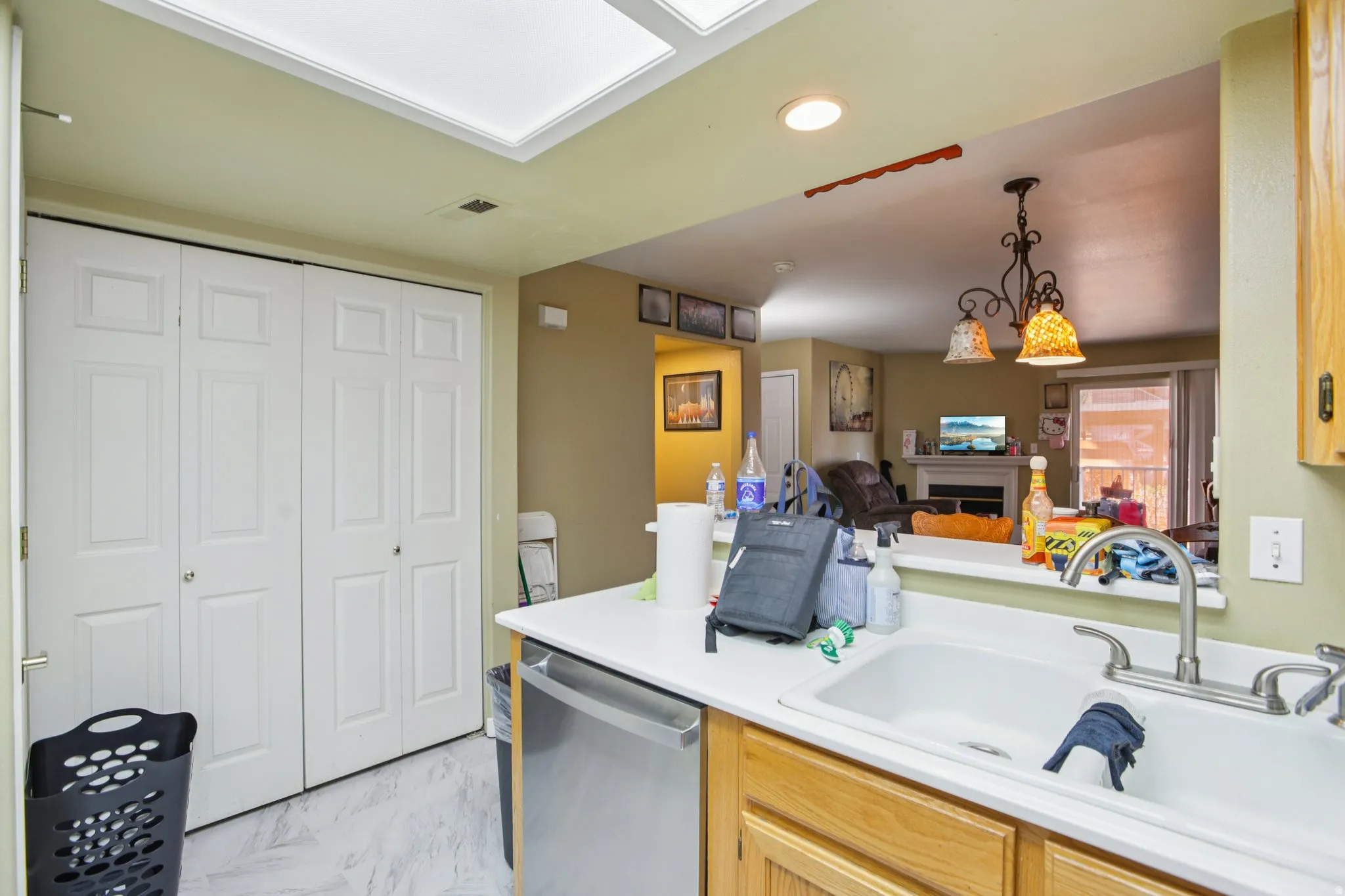 Kitchen featuring a stainless steel dishwasher, light countertops.