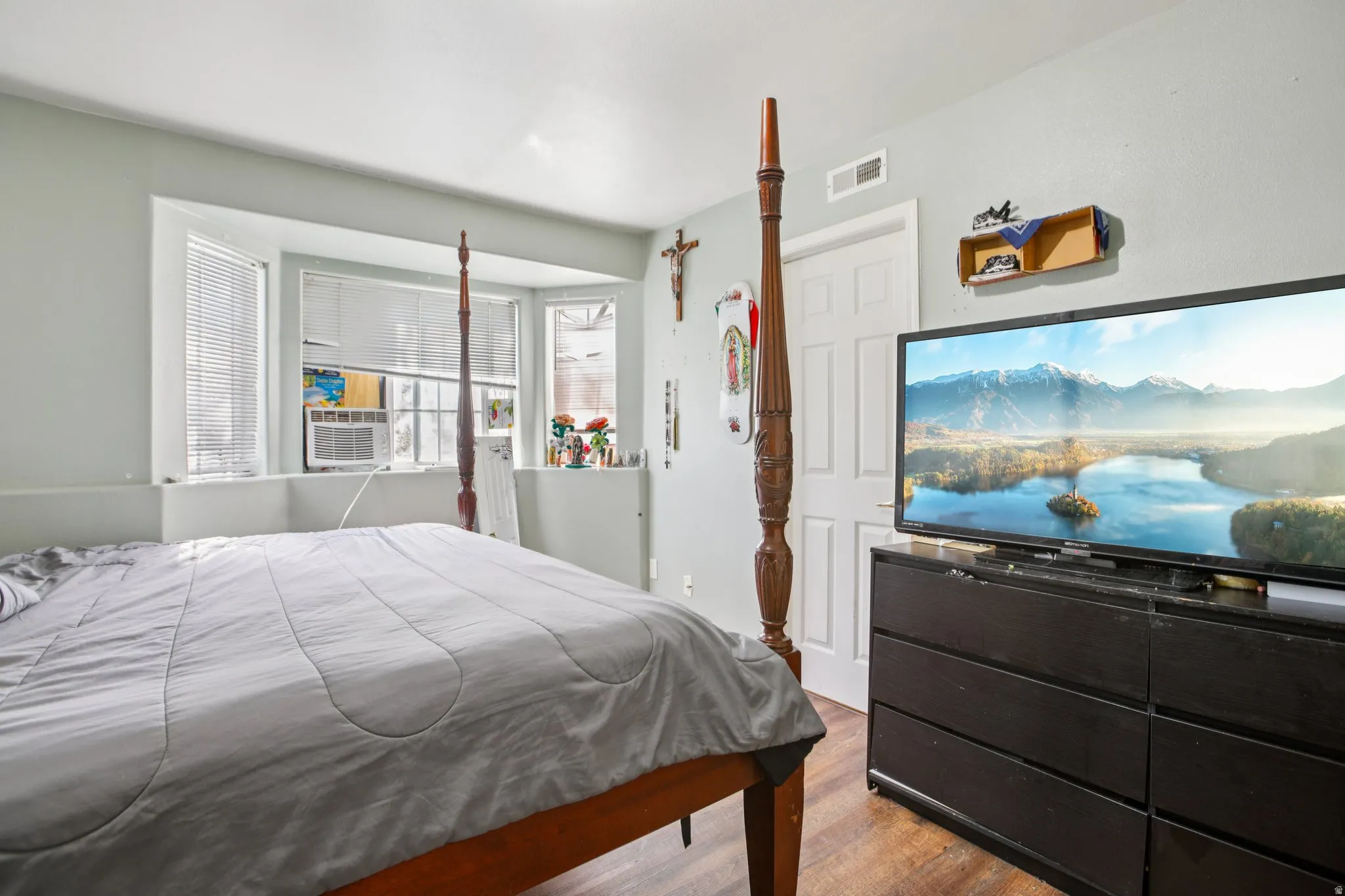 Bedroom with wood finished floors and cooling unit