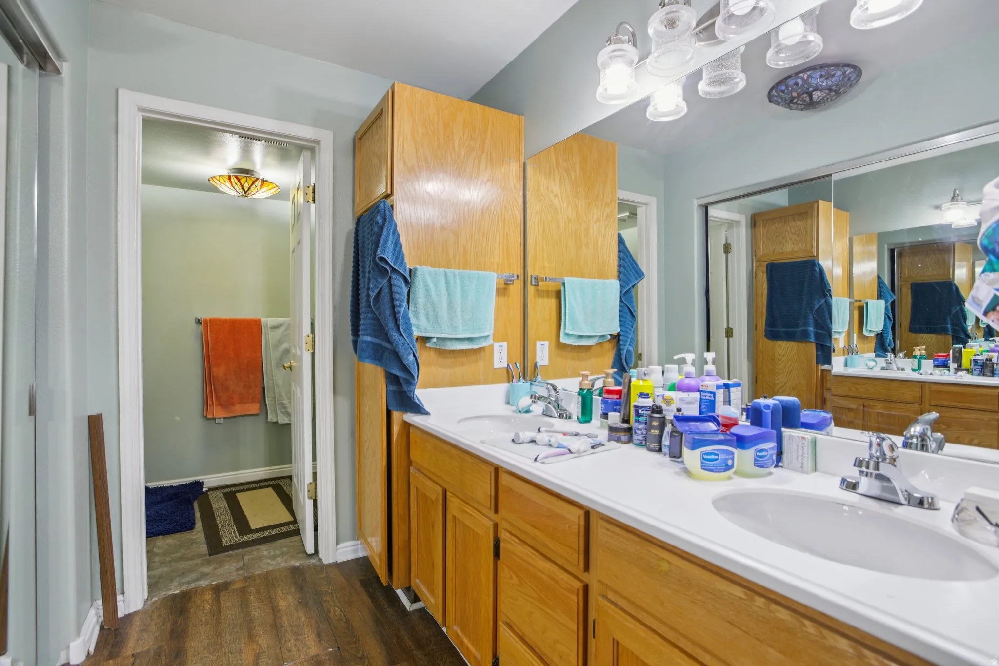 Bathroom featuring double vanity and dark wood finished floors
