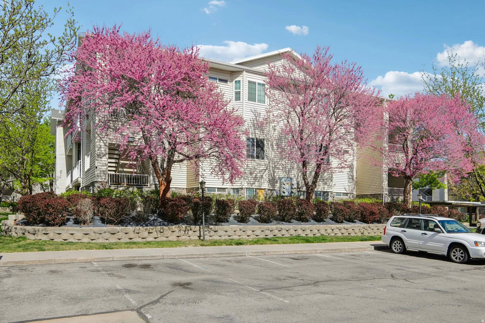 View of building exterior with uncovered parking