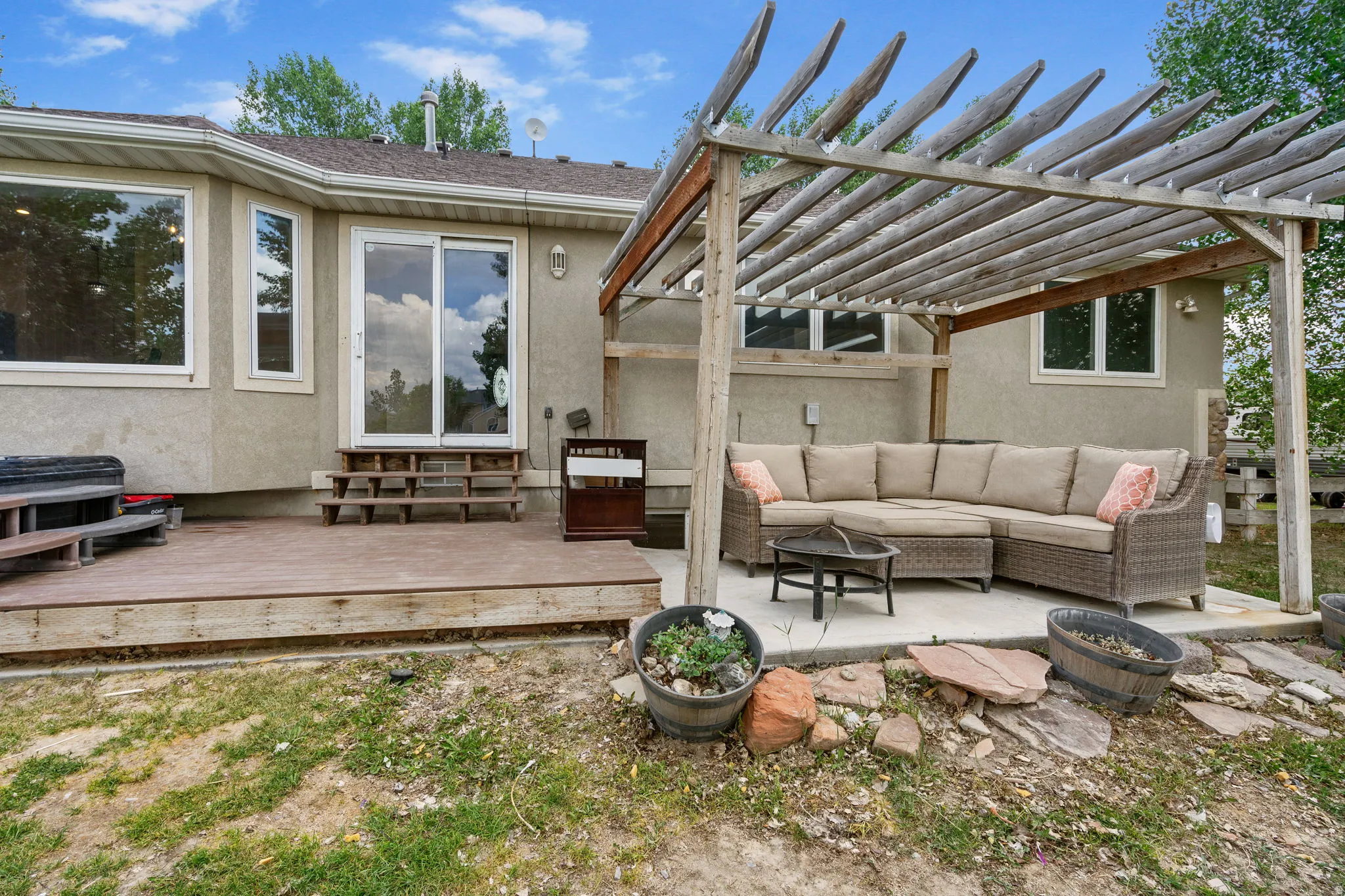 Wooden terrace with an outdoor hangout area, entry steps, and a pergola