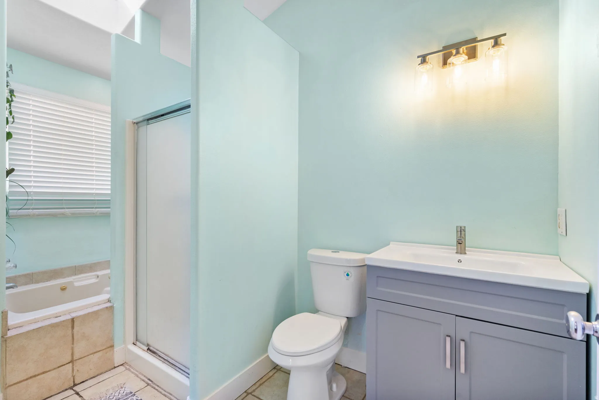 Primary bathroom with vanity, a shower stall, light tile patterned floors, and a bath