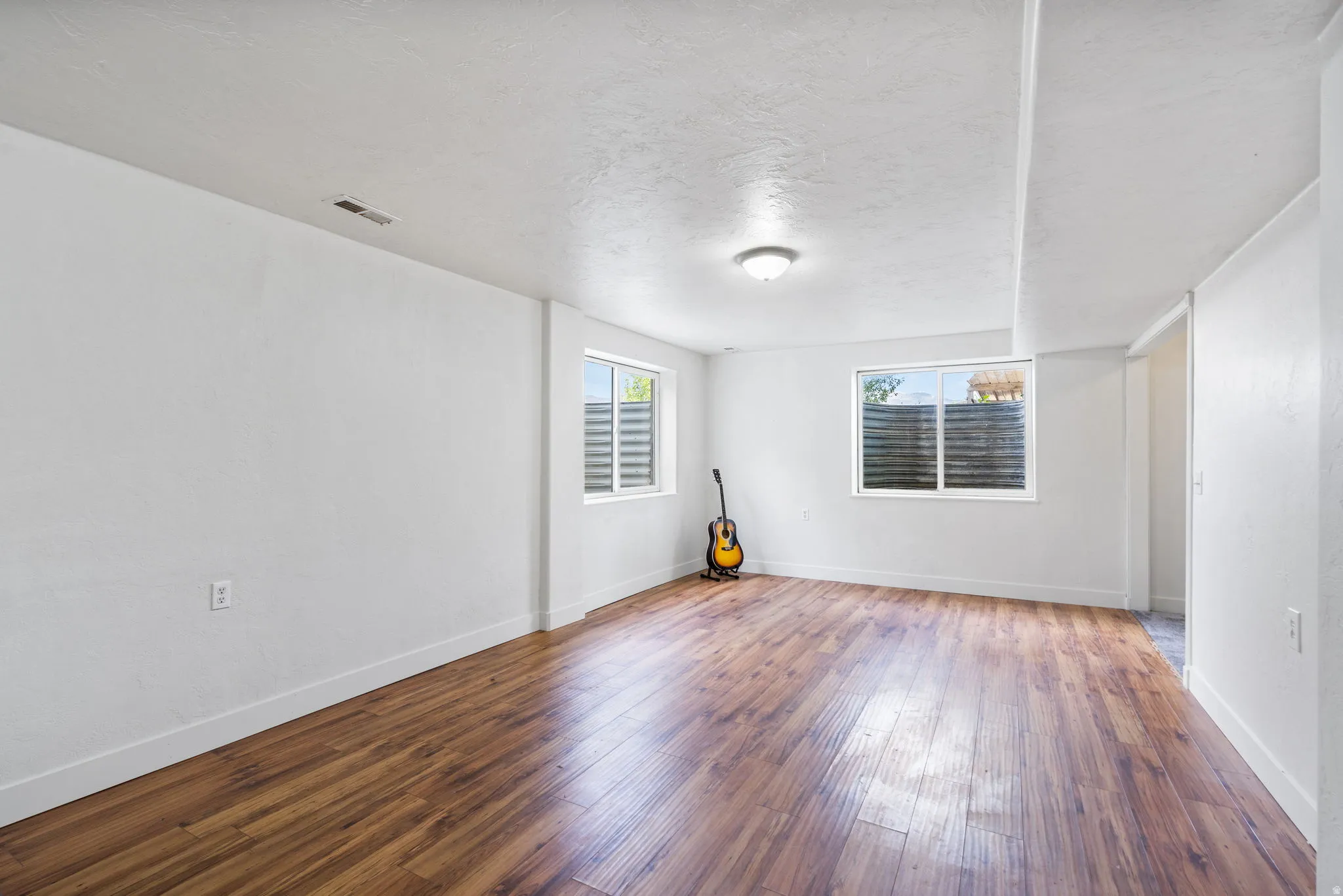 Spare room featuring wood-type flooring and a textured ceiling