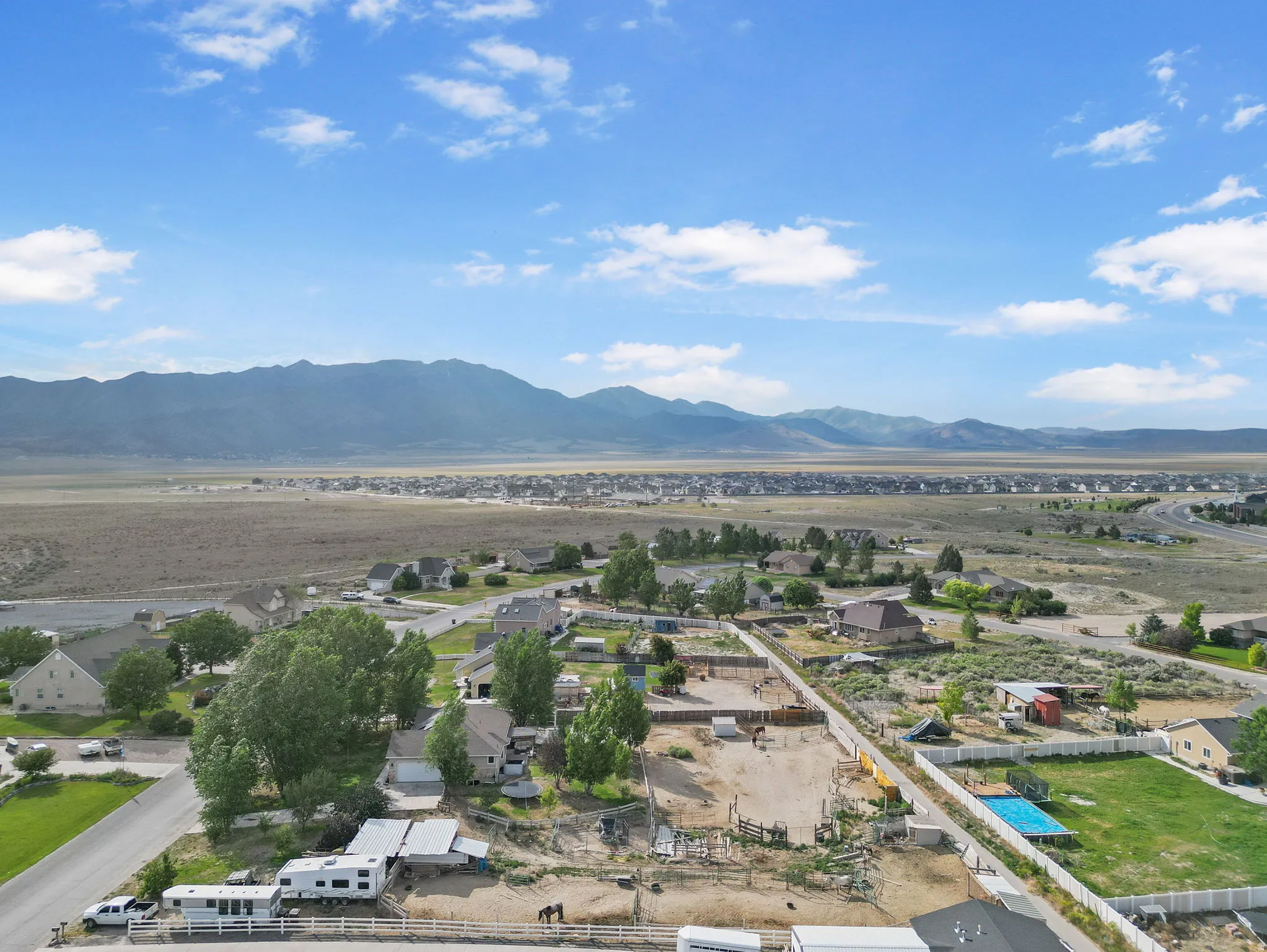 Aerial view of residential area with a mountainous background and a pool area