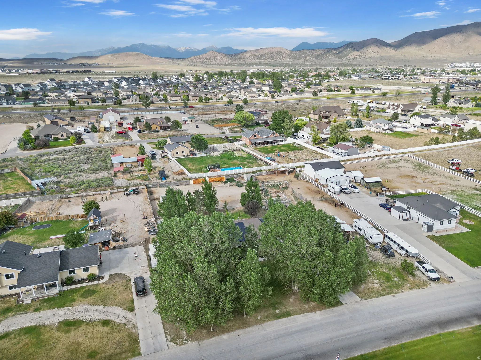 Aerial overview of property's location with nearby suburban area, a mountainous background, and property parcel outlined