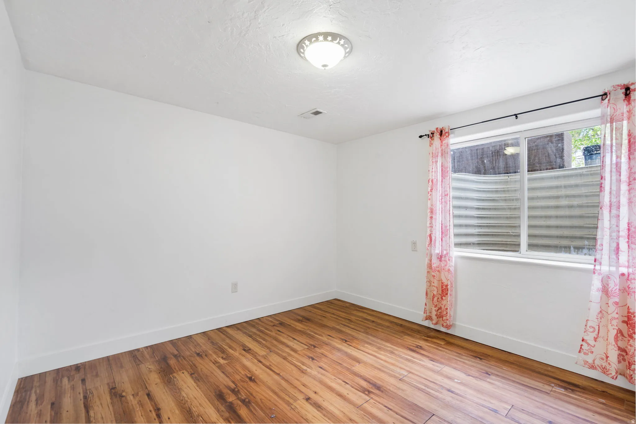Spare room featuring light wood-style floors and a textured ceiling