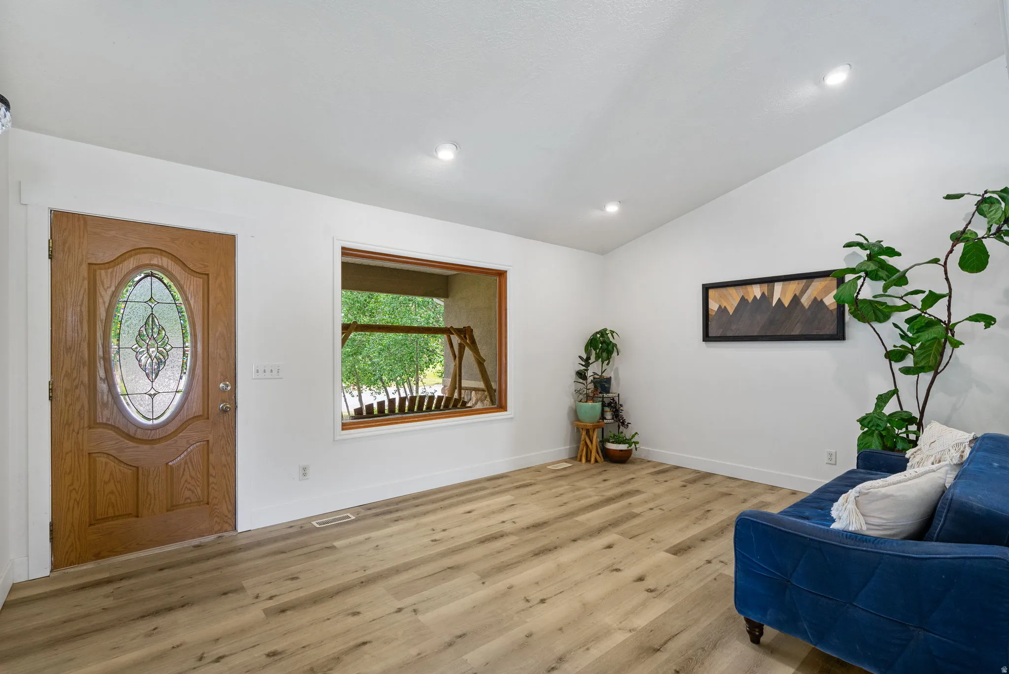 Entryway featuring light wood-style floors, lofted ceiling, and recessed lighting