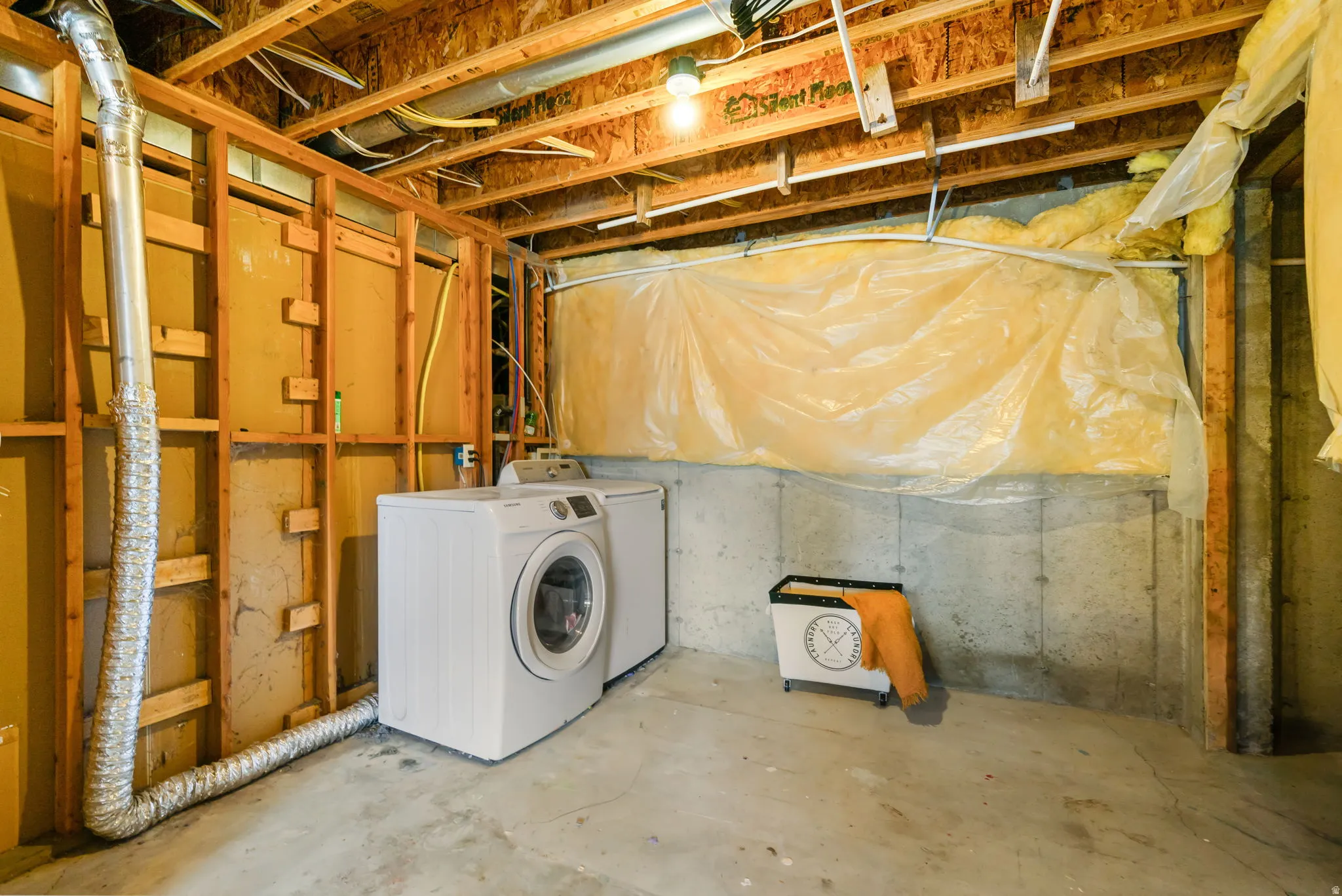Unfinished below grade area with washer and clothes dryer