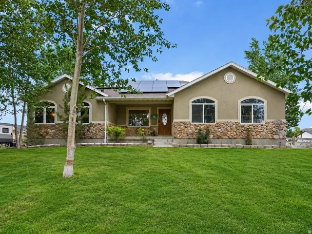 Stucco exterior with stone veneer accents, multiple arched windows, and a prominent front entry