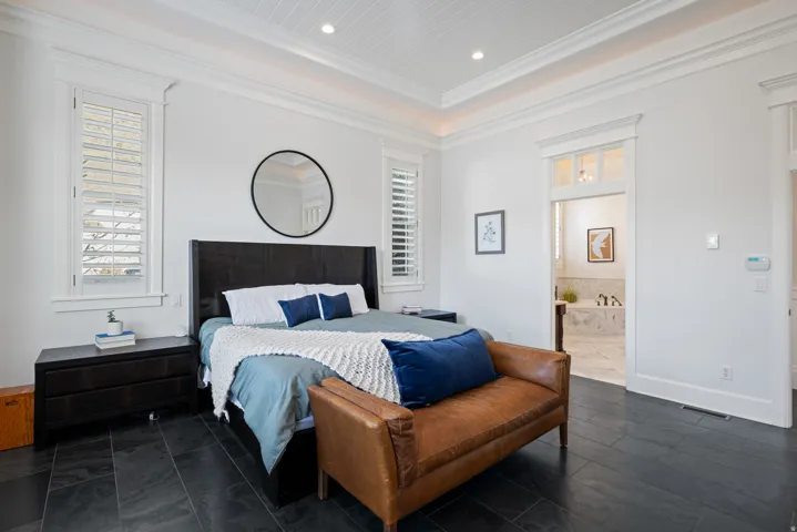 Bedroom featuring multiple windows, recessed lighting, ornamental molding, connected bathroom, and dark tile patterned flooring