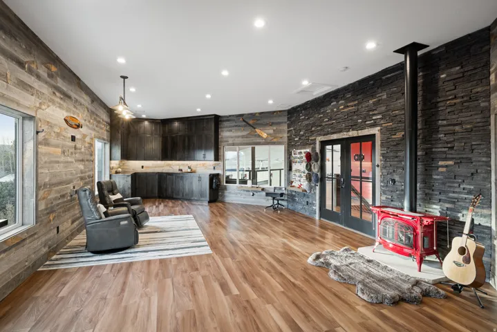 Sitting room with a wood stove, light wood-style floors, french doors, and recessed lighting