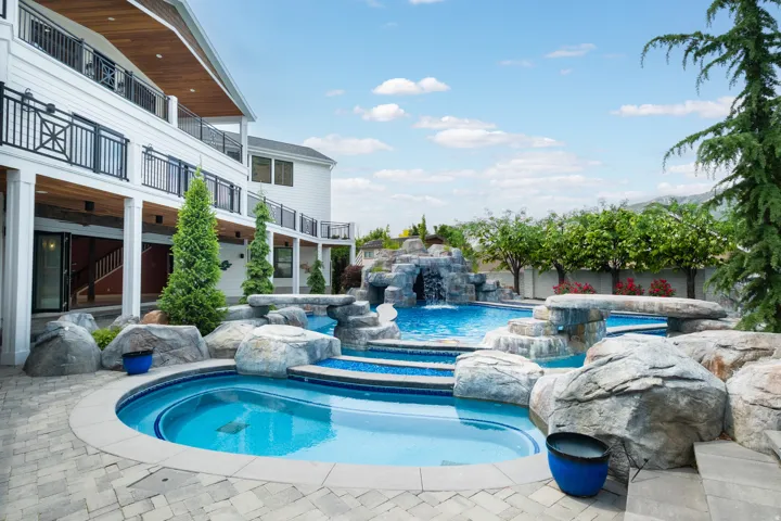Combined pool / hot tub with a balcony and a patio area