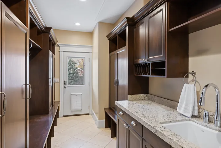 Laundry room with a sink and light tile patterned floors