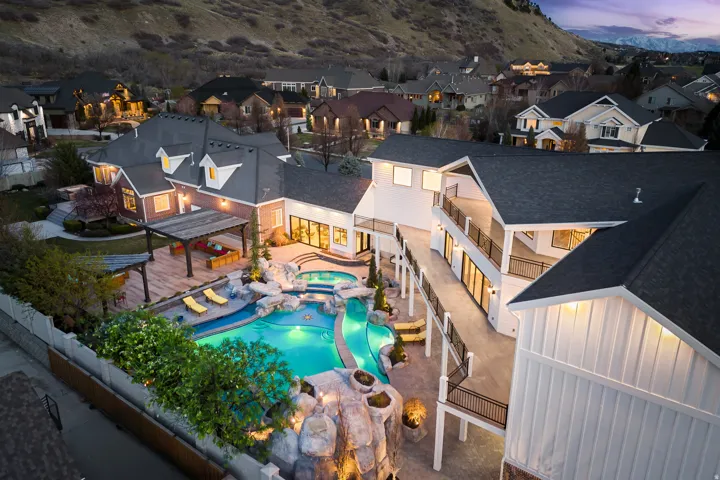 Rear view of property with a patio area, a fenced backyard, board and batten siding, and a pool with connected hot tub