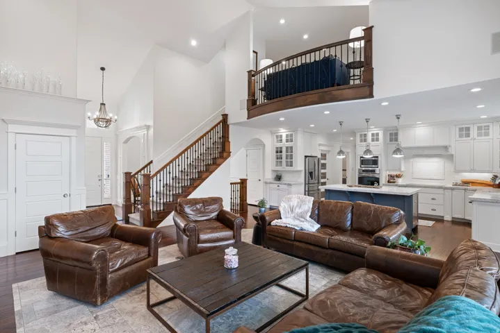 Living area with wood finished floors, a high ceiling, and suspended lighting