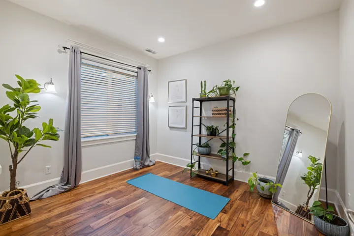 Exercise area featuring plenty of natural light, wood finished floors, and recessed lighting
