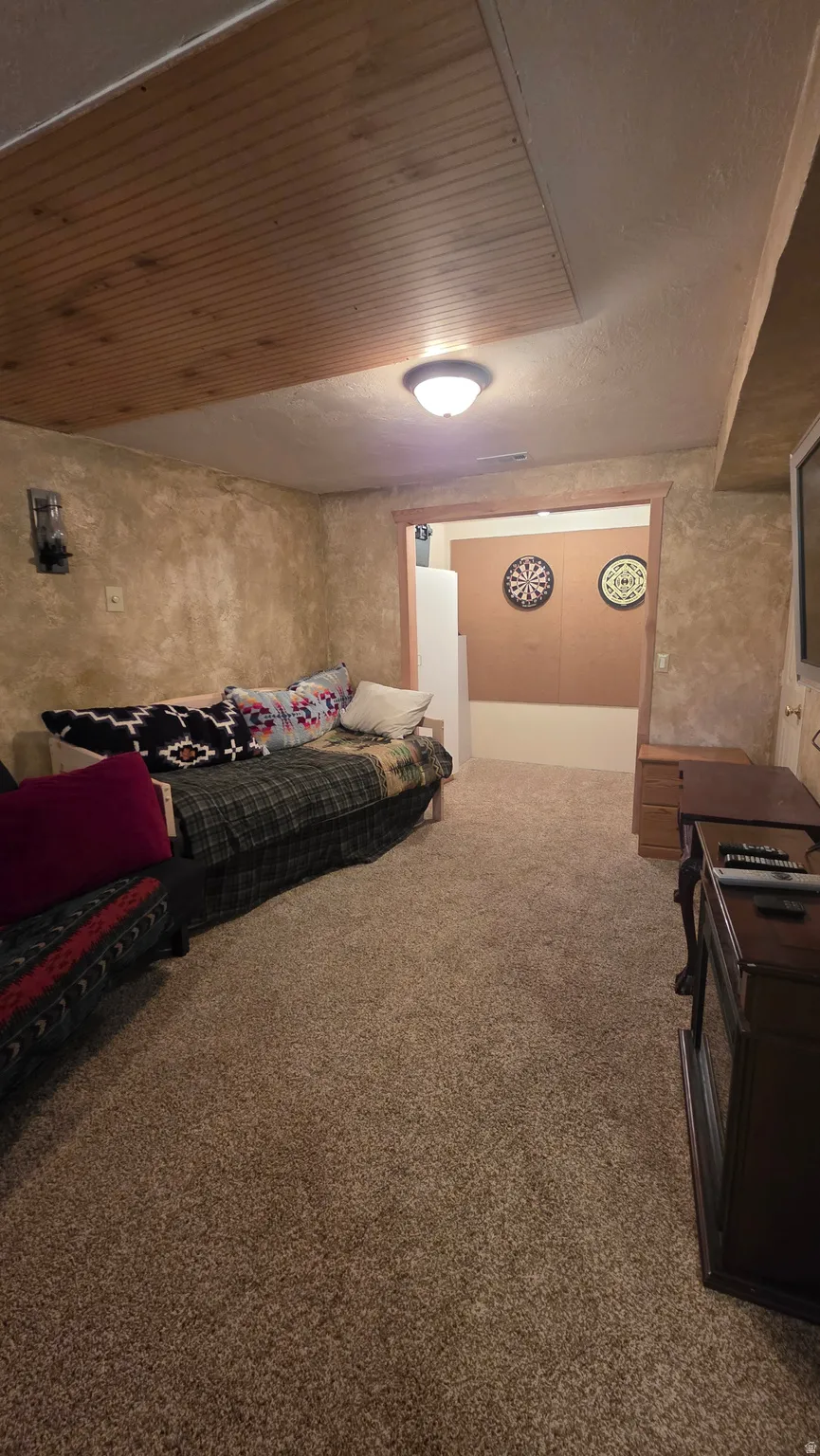 Bedroom featuring carpet flooring and wooden ceiling