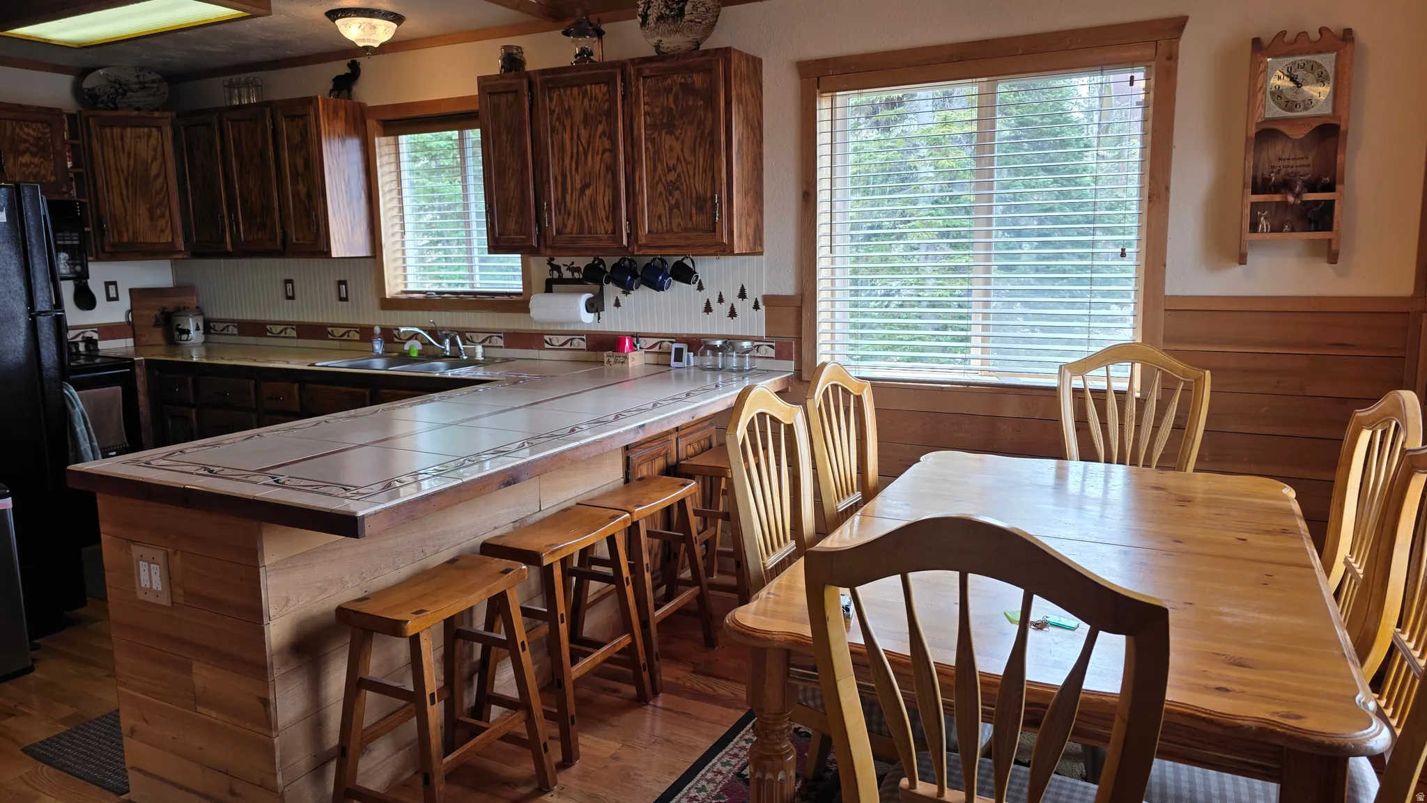 Kitchen featuring wood cabinetry, a tiled countertop, and a breakfast bar with built-in seating