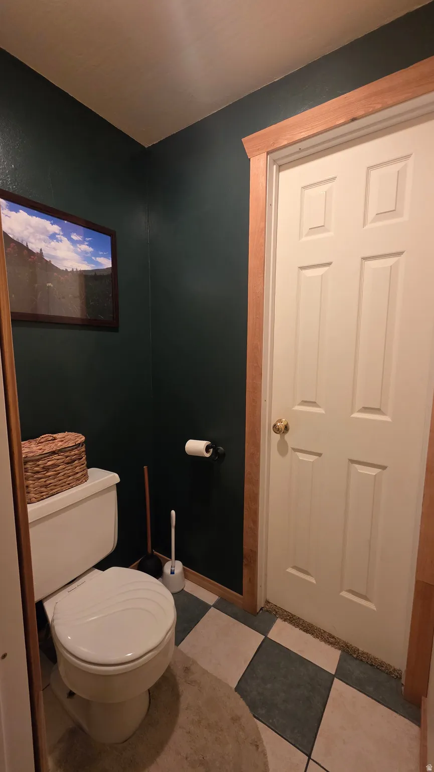 Bathroom featuring toilet and light flooring