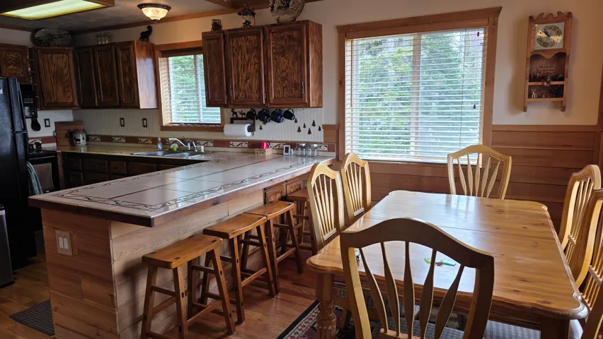 Kitchen featuring wood cabinetry, a tiled countertop, and a breakfast bar with built-in seating