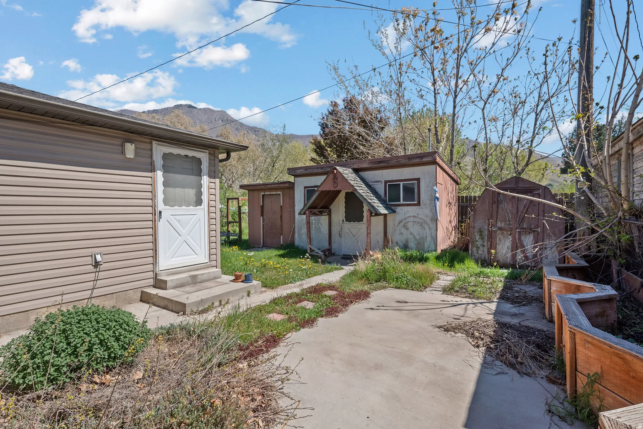 View of yard featuring a storage shed, entry steps, and a mountain view