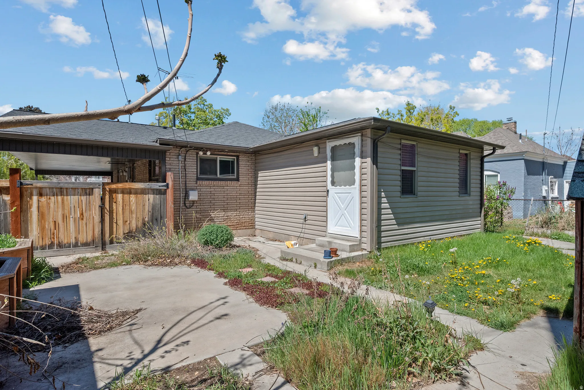 Rear view of property featuring brick siding and roof with shingles