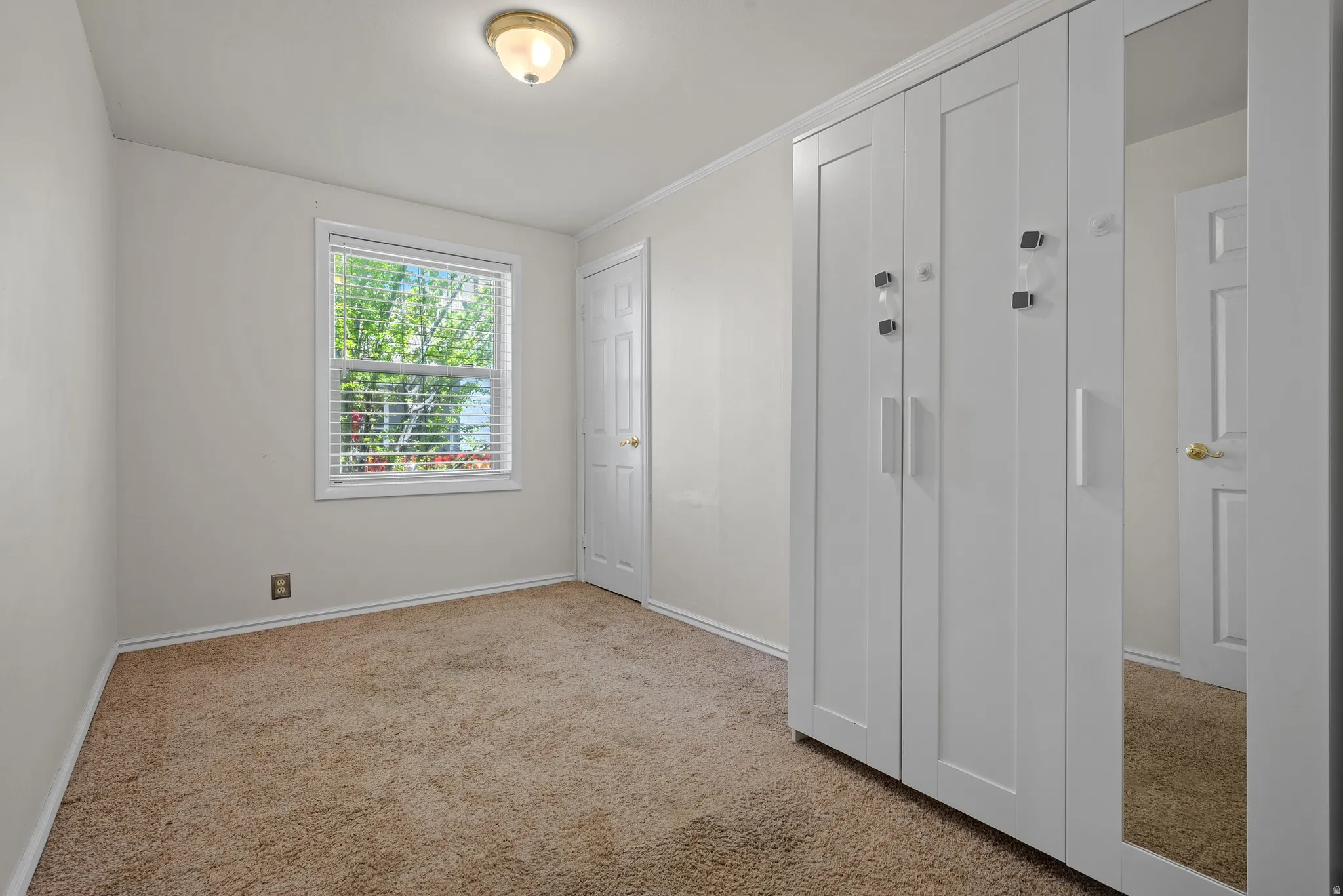 Unfurnished bedroom with light carpet and a closet