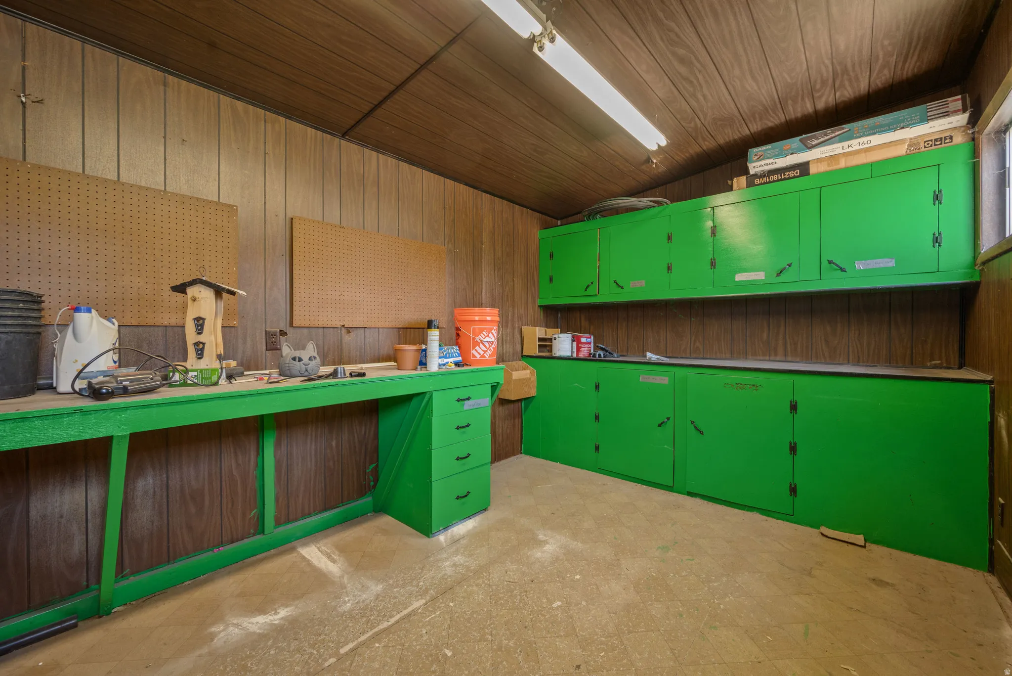 Unfurnished office featuring wood walls, light flooring, and lofted ceiling