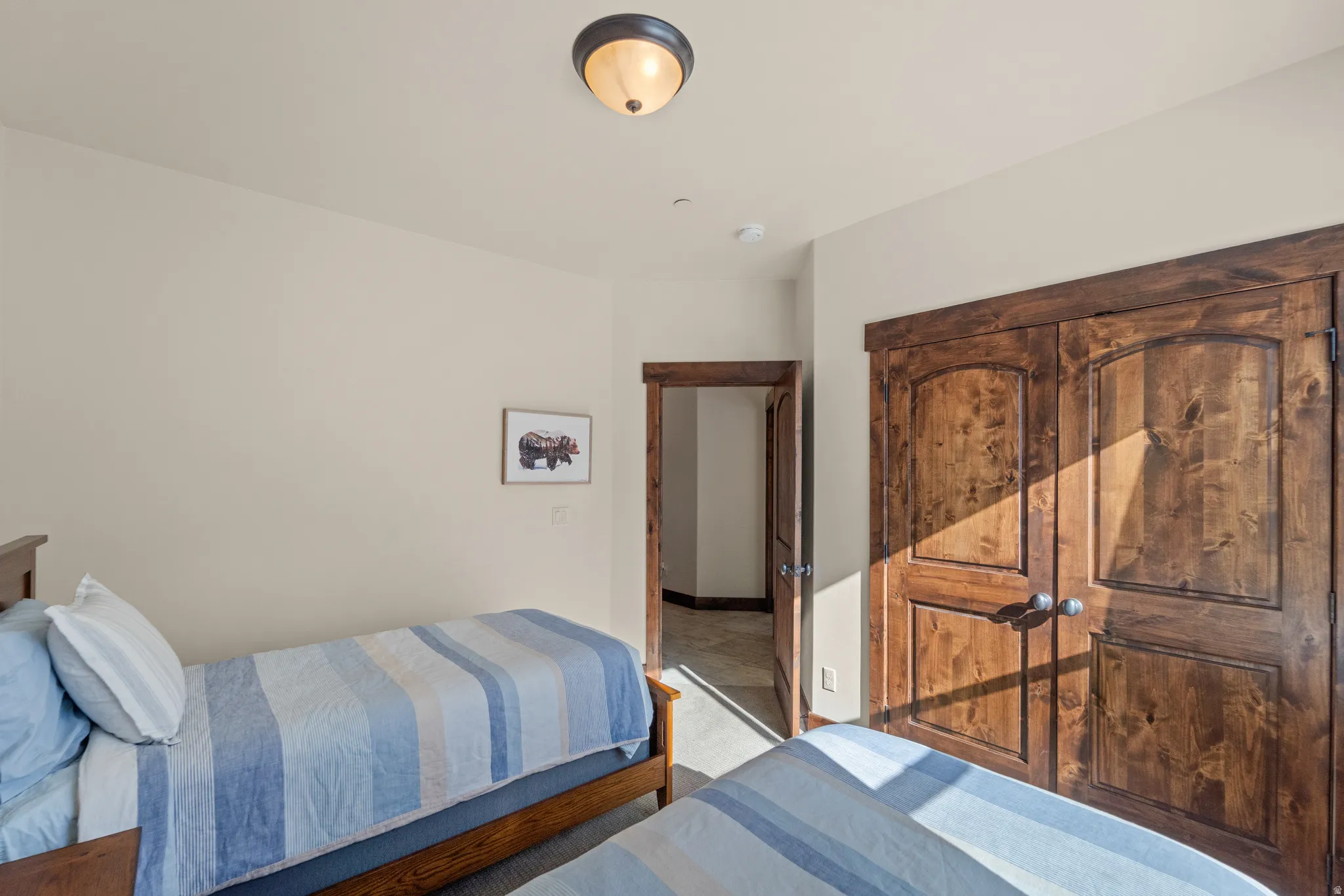 Bedroom with light carpet and a closet