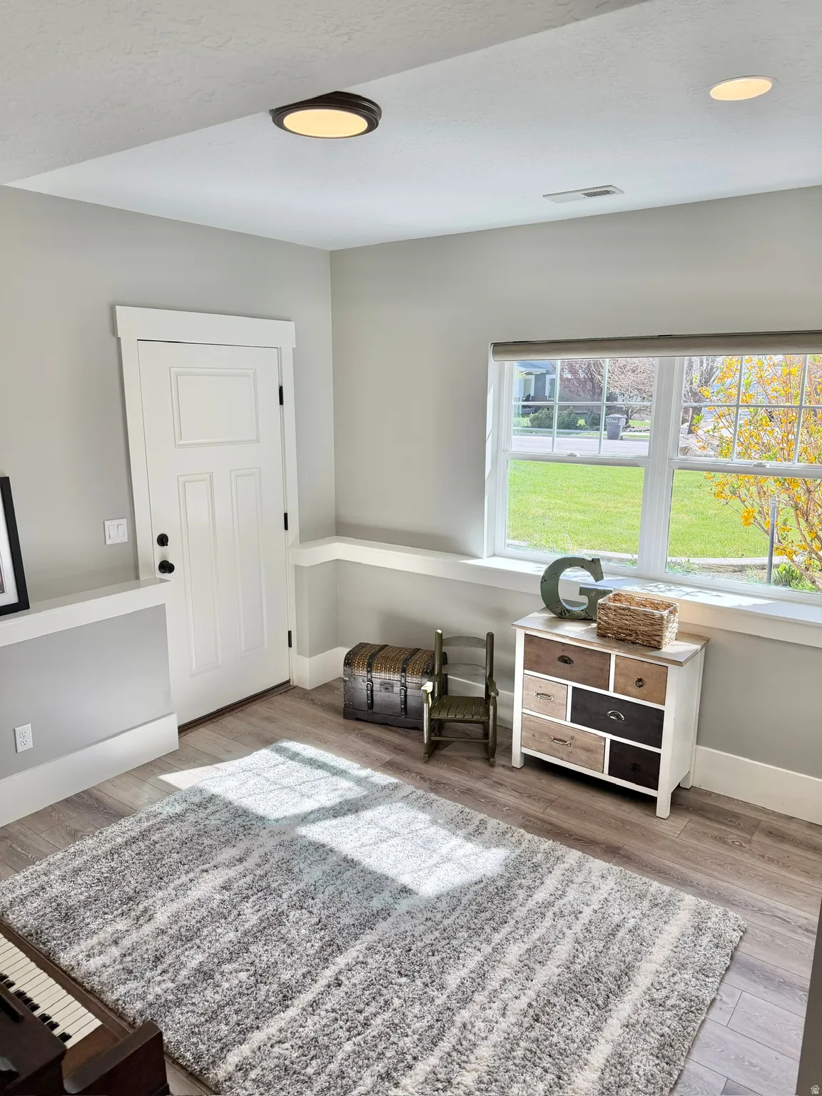 Living area with light wood-style floors and baseboards