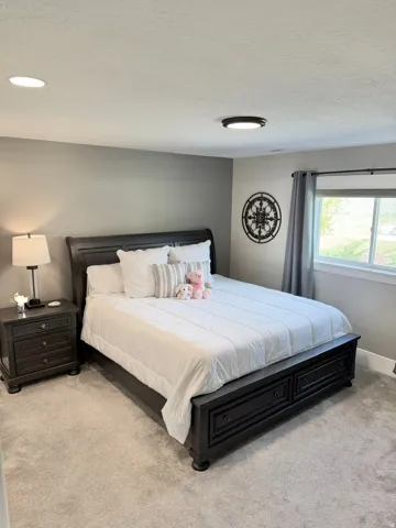 Bedroom with light carpet and a textured ceiling