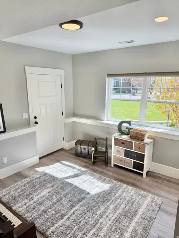 Living area with light wood-style floors and baseboards