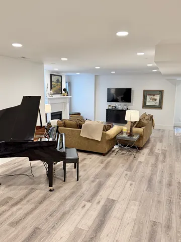 Living room featuring a fireplace, light wood-style flooring, and recessed lighting