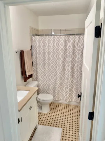 Bathroom featuring vanity and shower / bathtub combination with curtain