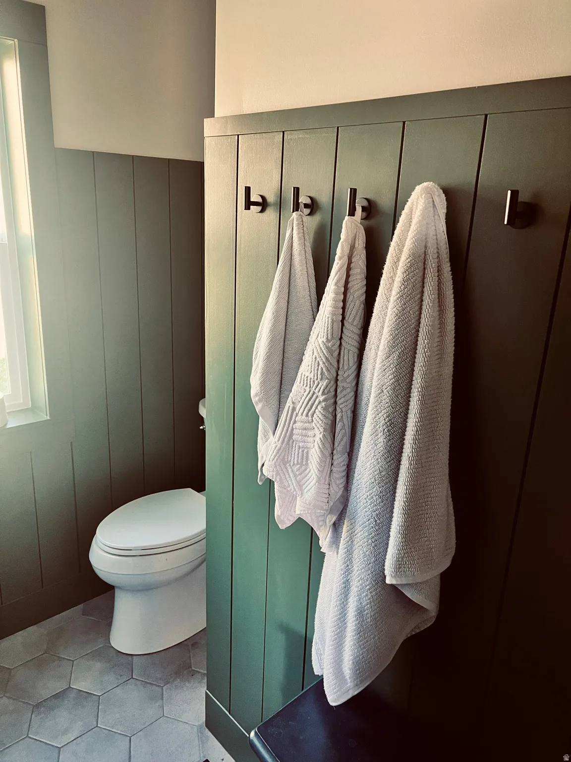 Bathroom with a decorative wall and light tile patterned floors