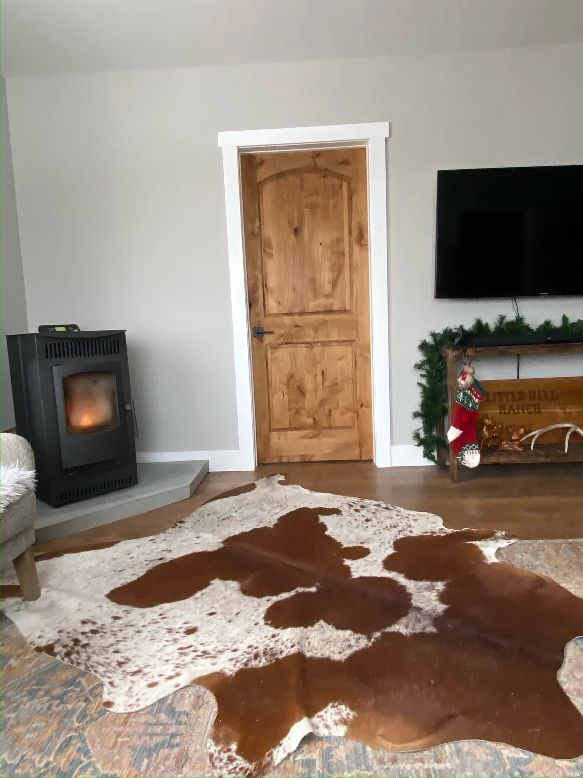 Living area featuring a wood stove, wood finished floors, and heating unit