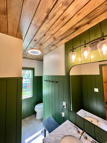 Bathroom featuring a wainscoted wall, vanity, wooden ceiling, wooden walls, and tile patterned flooring