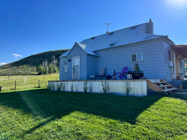 Back of property with a yard, a metal roof, a patio area, a mountain view, and a chimney