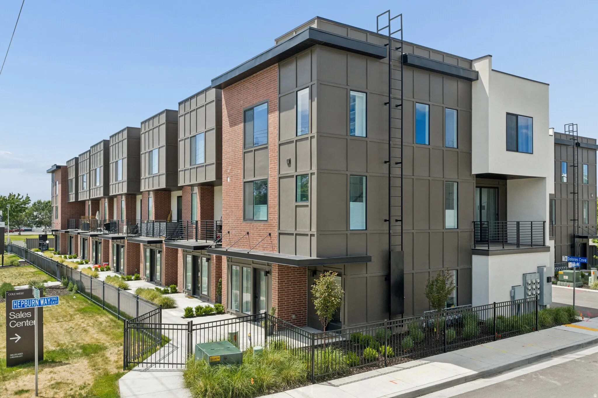 Contemporary multi-story townhome development featuring brick and paneling exterior