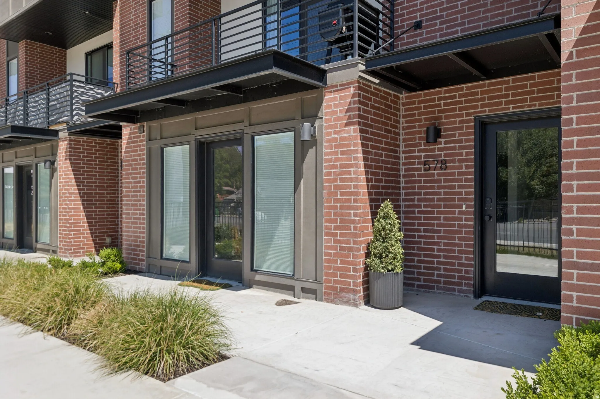 Red brick facade featuring black-framed glass doors and windows