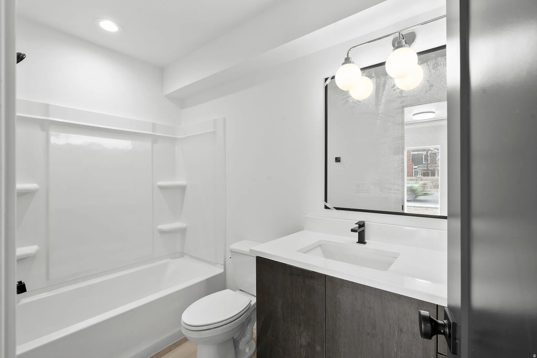 Full bathroom featuring vanity, shower / bath combination, and recessed lighting