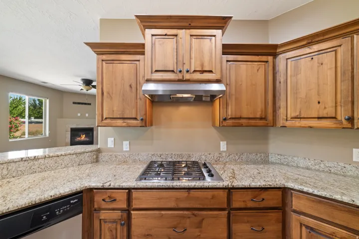 Kitchen featuring stainless steel appliances, light stone countertops, and wood finish cabinets.