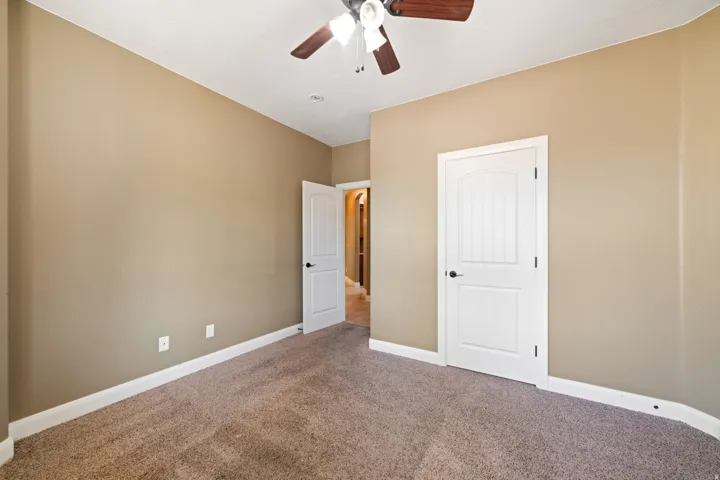 Unfurnished bedroom featuring carpet flooring and a ceiling fan