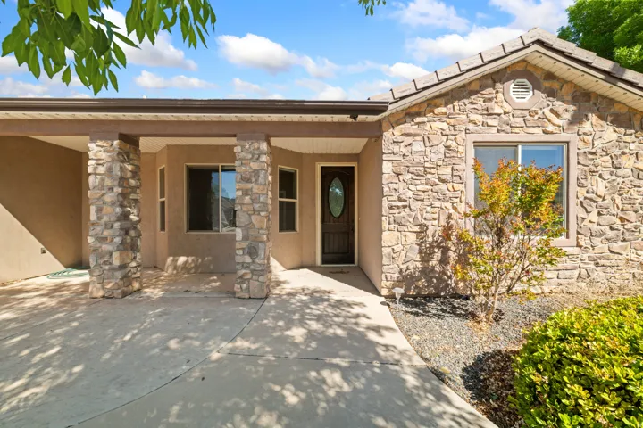 Doorway to property featuring stone siding and stucco siding