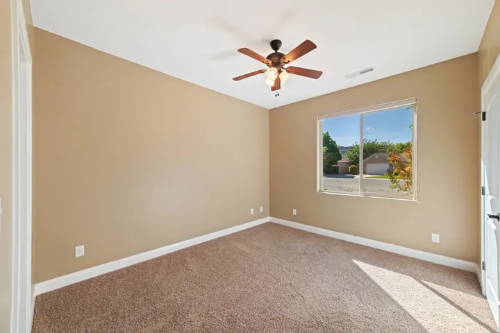 Spare room featuring light carpet and a ceiling fan