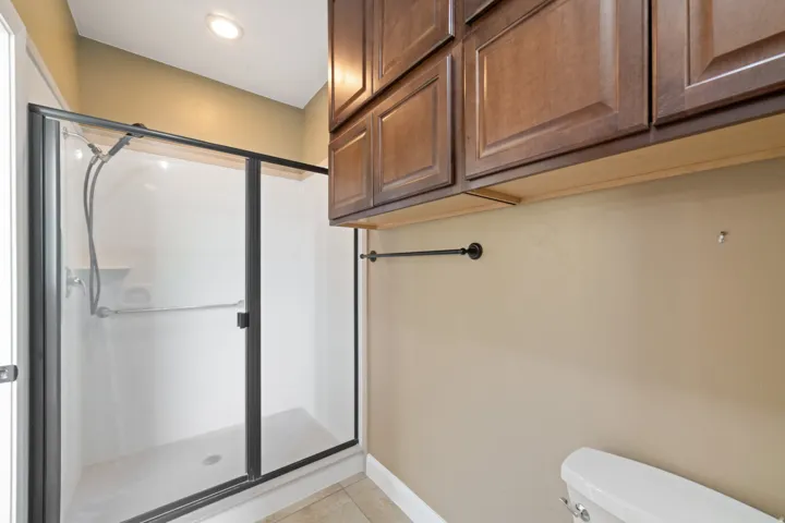 Bathroom featuring a shower stall and light tile patterned floors